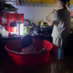 Nghẹn lòng hình ảnh người mẹ đặt con vào chậu, vừa trông vừa nấu vội bữa cơm chiều giữa nước lũ